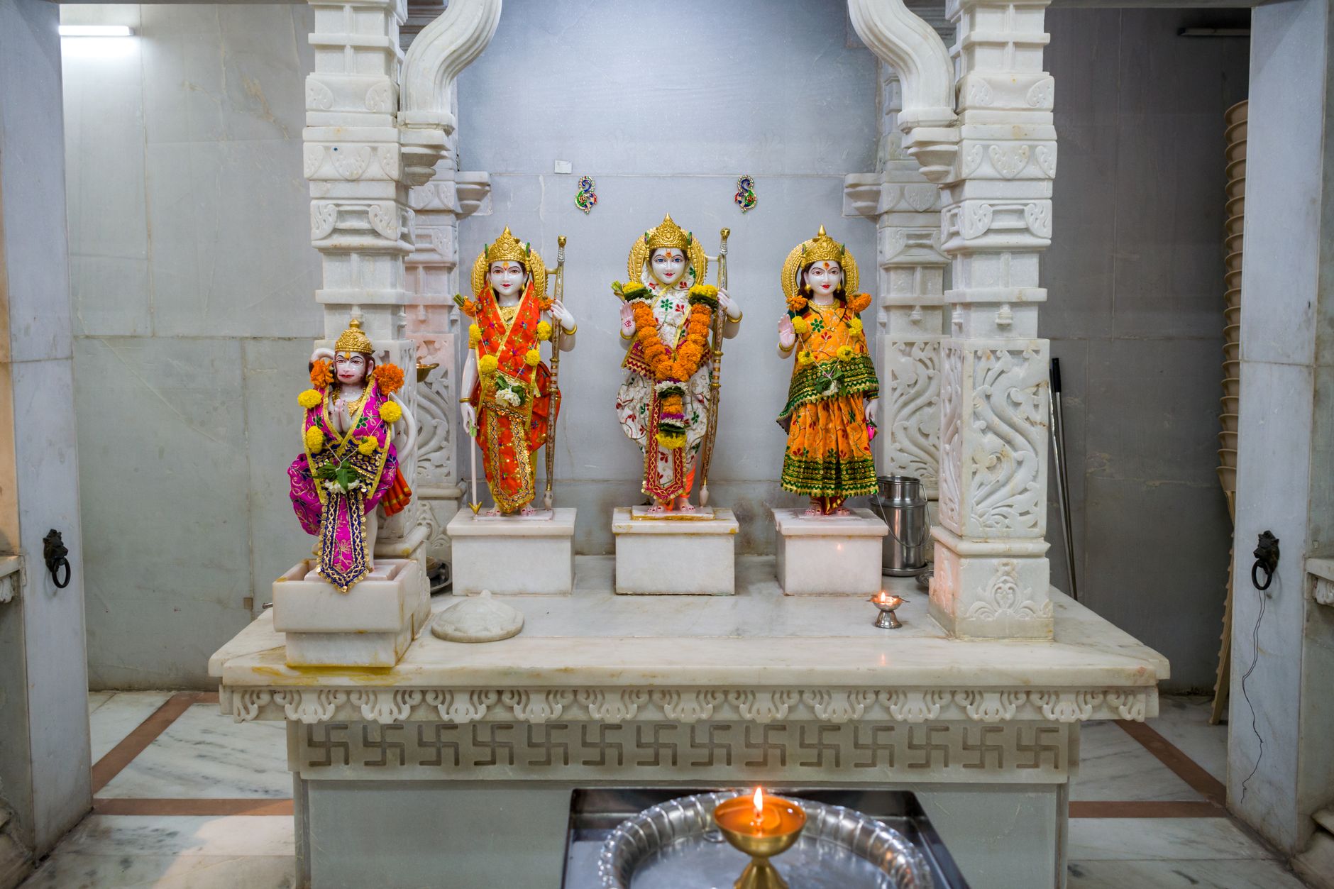 Decorative Hindu deity statues adorned with flowers inside a traditional Mumbai temple.