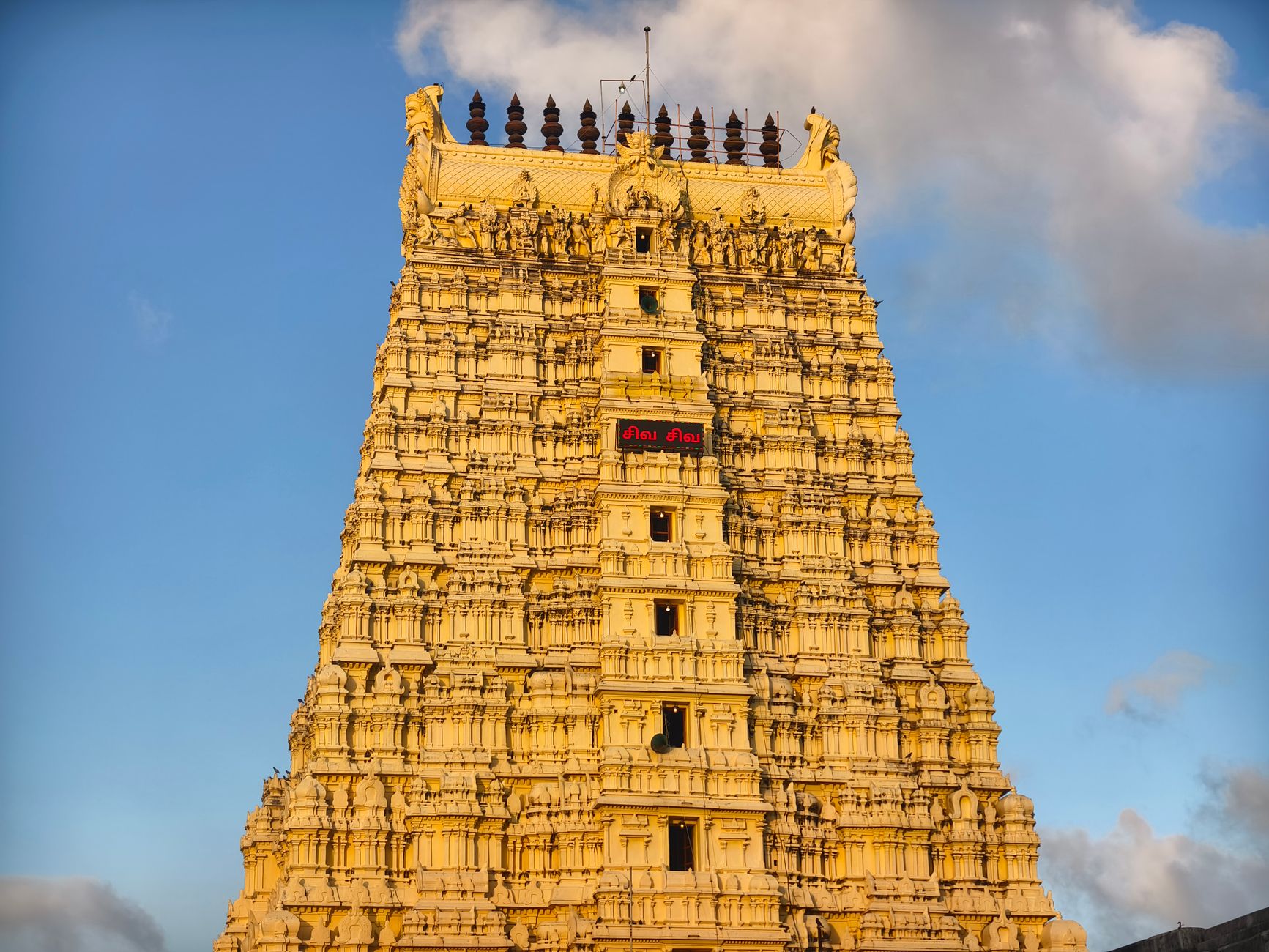 Rameswaram temple gopuram with intricate carvings under a clear blue sky.