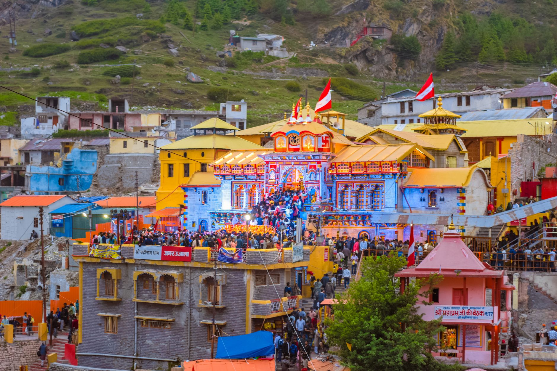 Colorful view of Badrinath Temple, bustling with activity and visitors in Uttarakhand, India.