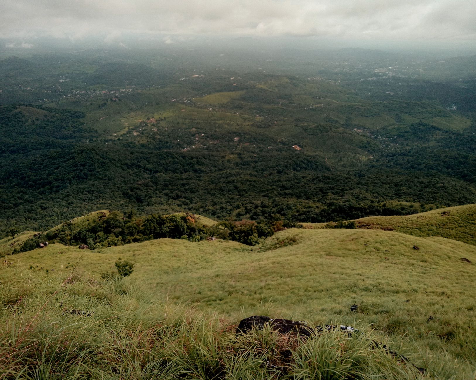 A breathtaking aerial view of rolling hills and dense forests in Kerala, India.