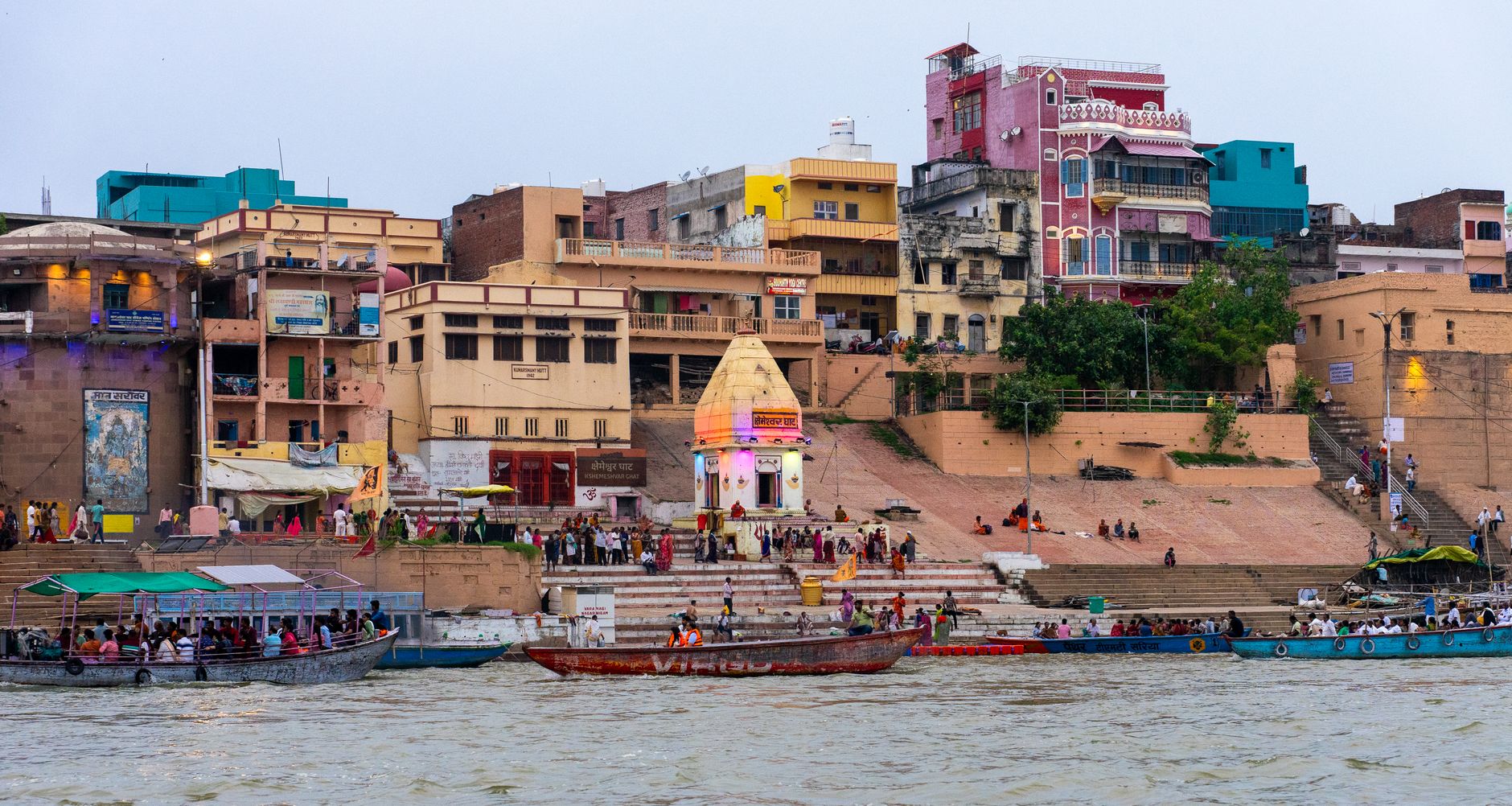 Colorful riverside buildings and boats on the Ganges River in Varanasi, India.